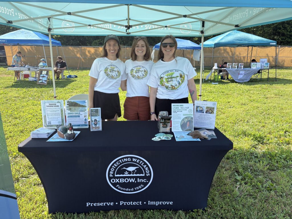 Oxbow staff at the outreach table under the "Preserve, Protect, Improve" tent